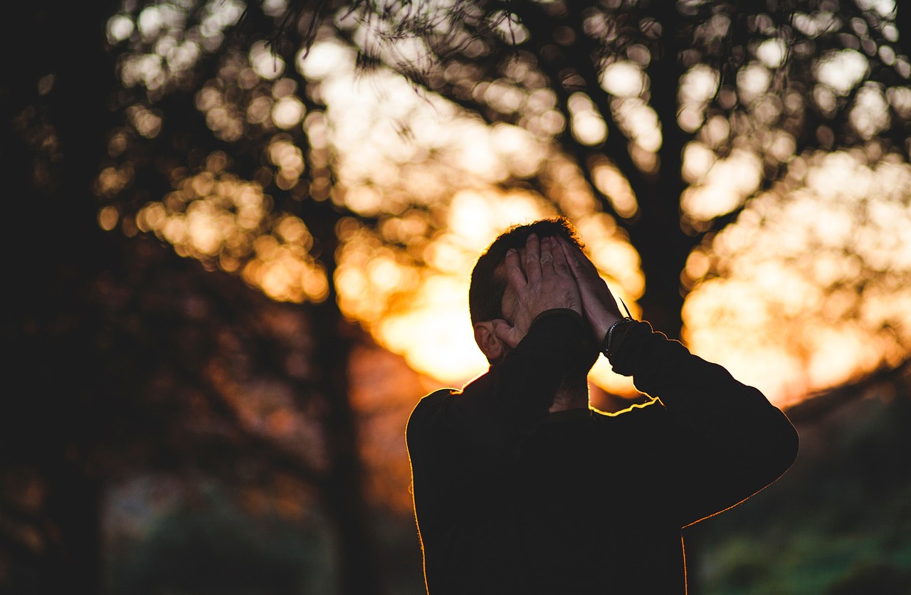 A sad man covering his face | Source: Pixabay