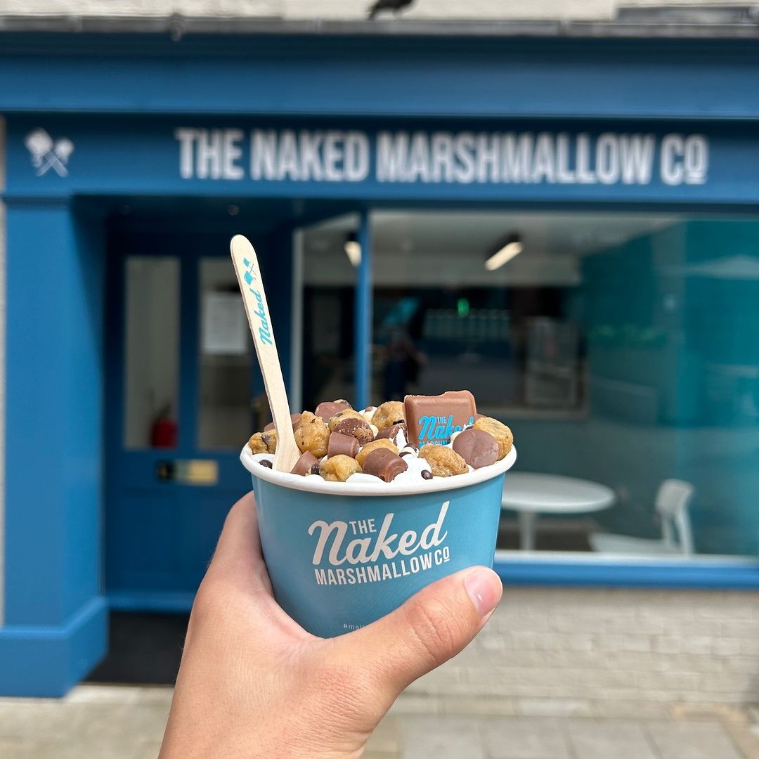 Branded ice cream cup displayed in front of a store facade.