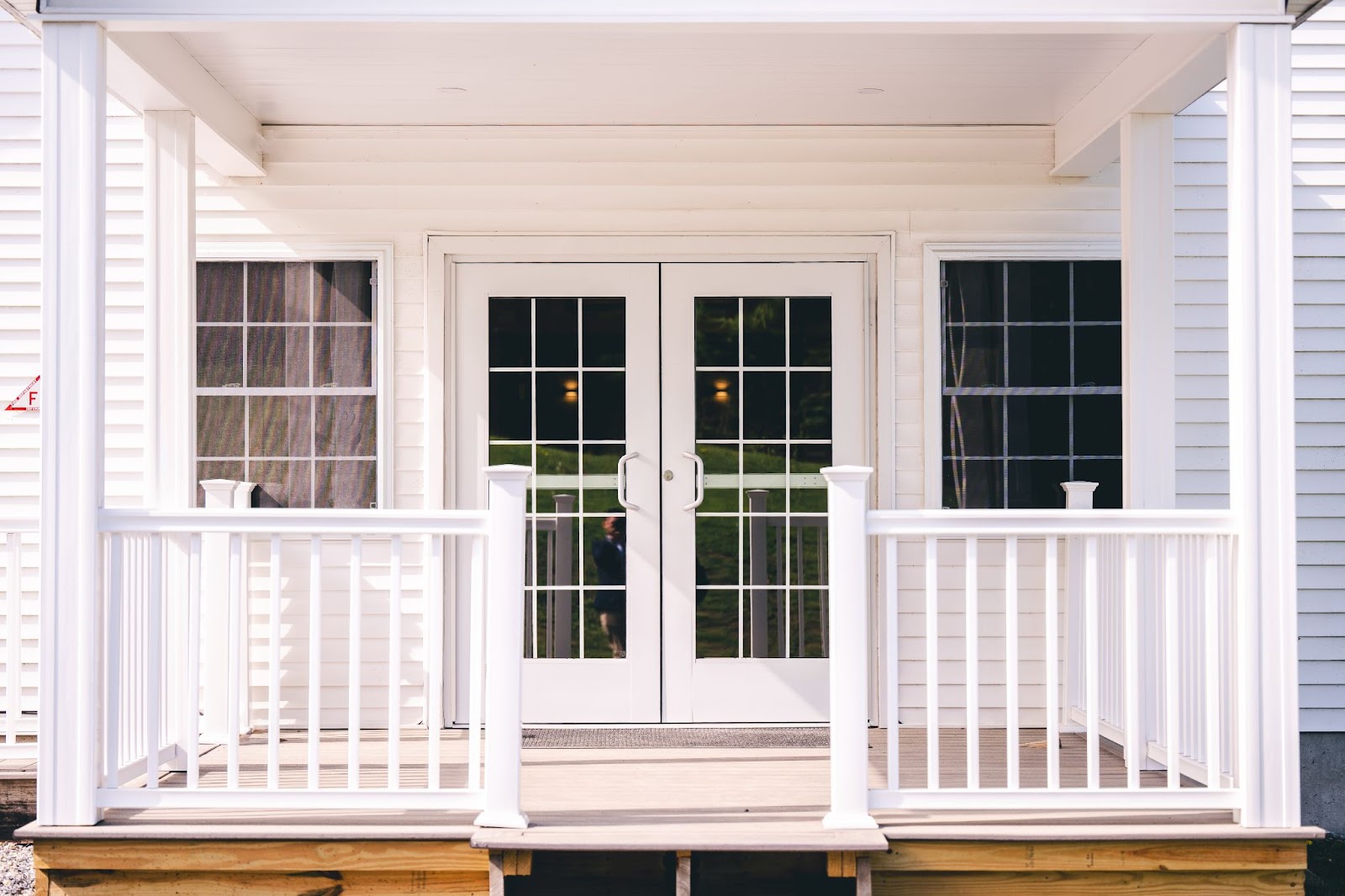 Vinyl deck railing in front of glass doors and windows. 