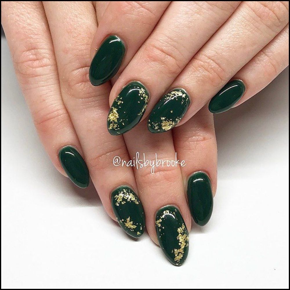 Close up of hands with Christmas Green Nails having  Green & Gold Leaf Design