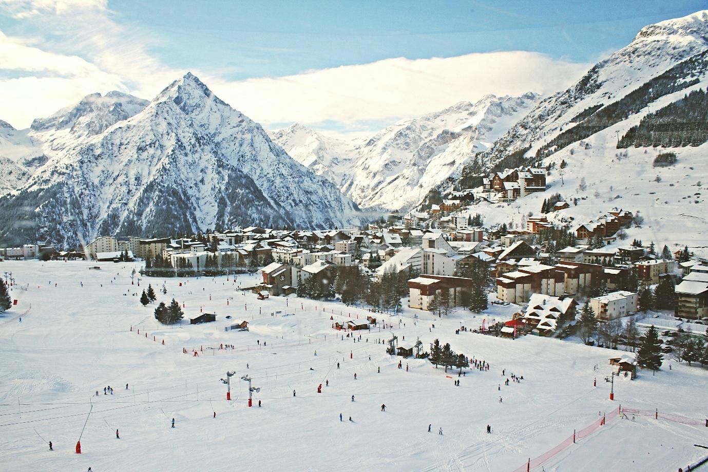 A snowy mountain with buildings and ski slopes  AI-generated content may be incorrect.
