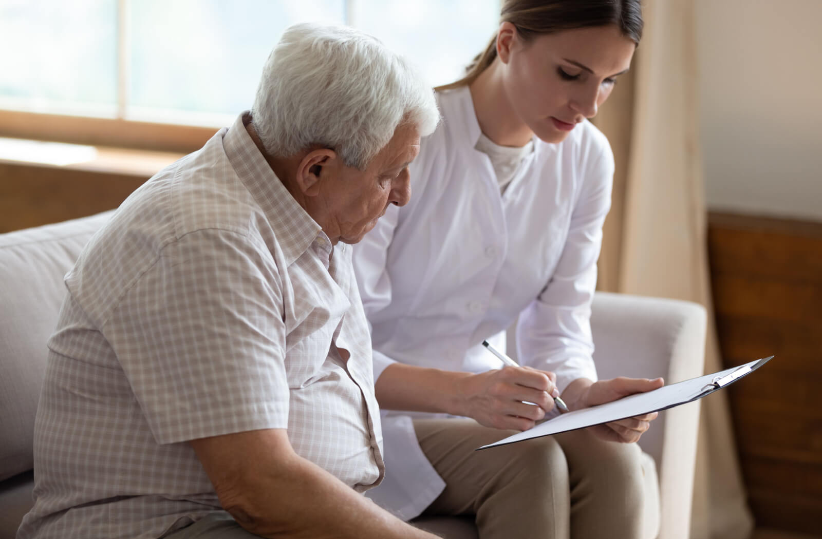 An older adult watching as their Power of Attorney guardian is explaining a legal document to them.
