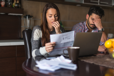 signs that your homes insulation isnt performing well couple reviewing energy bills custom built michigan