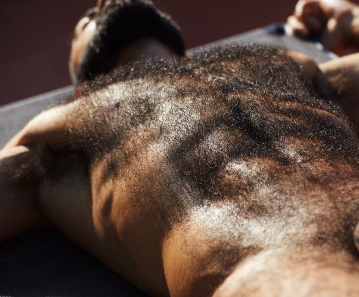 close up of saleh helalat lying on his back showing off his gay hairy muscle chest and sweaty naked body