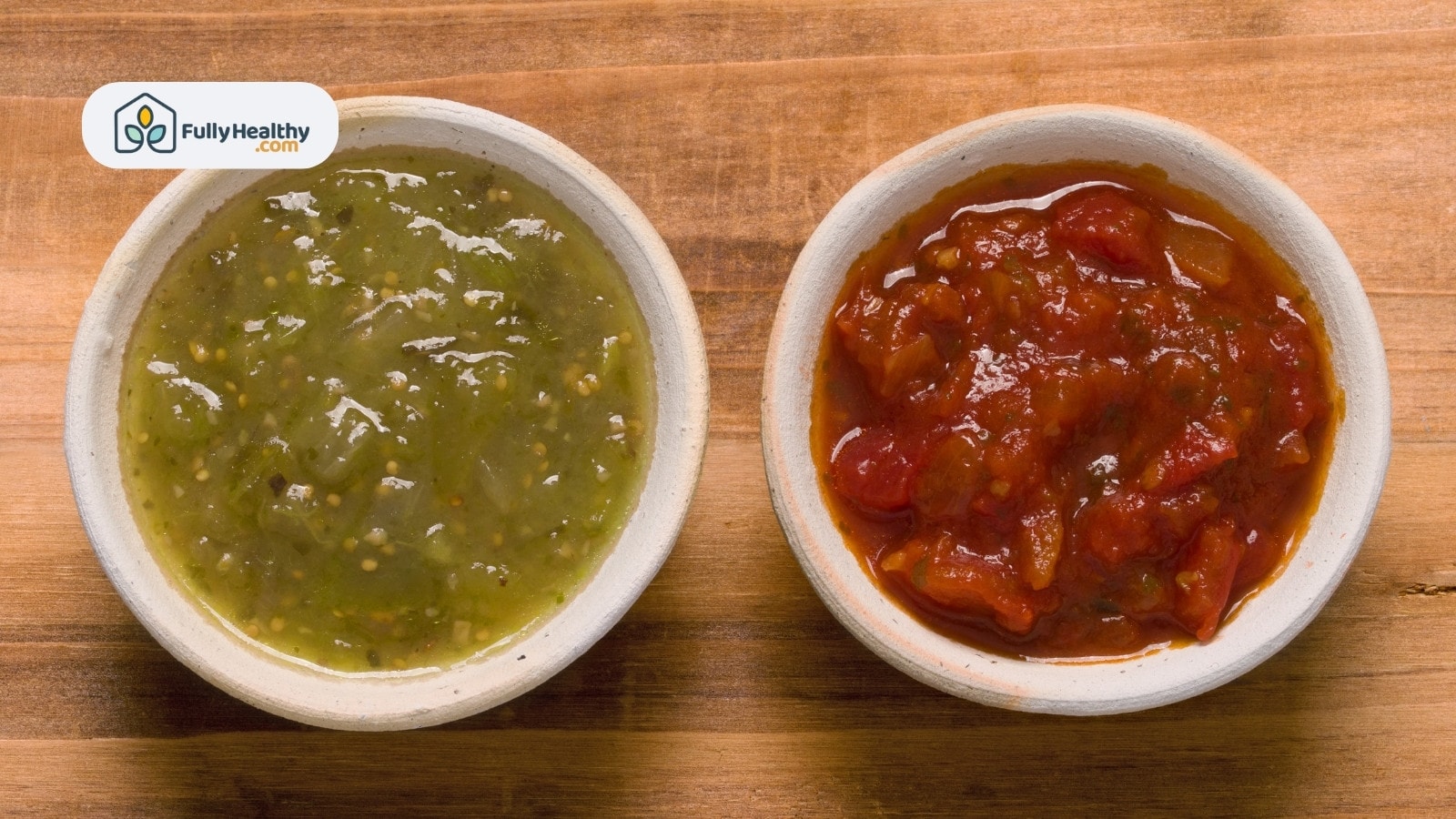 Red and green salsa bowls side by side on wooden background
