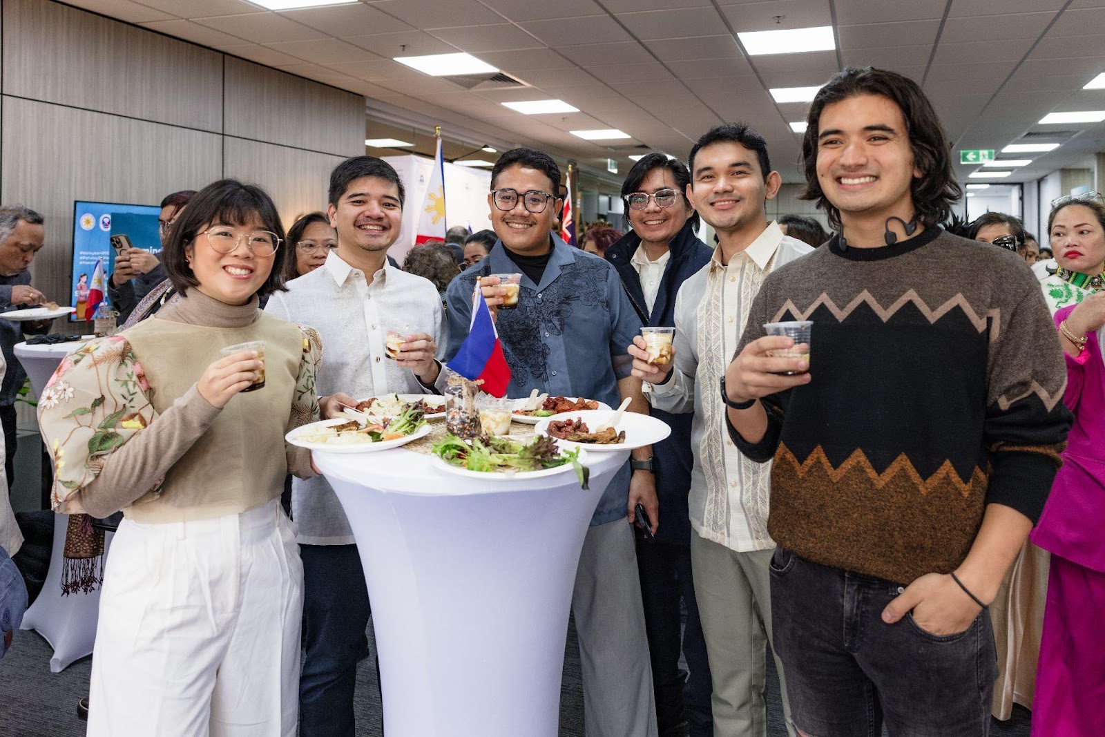 A group of people standing in a roomDescription automatically generated