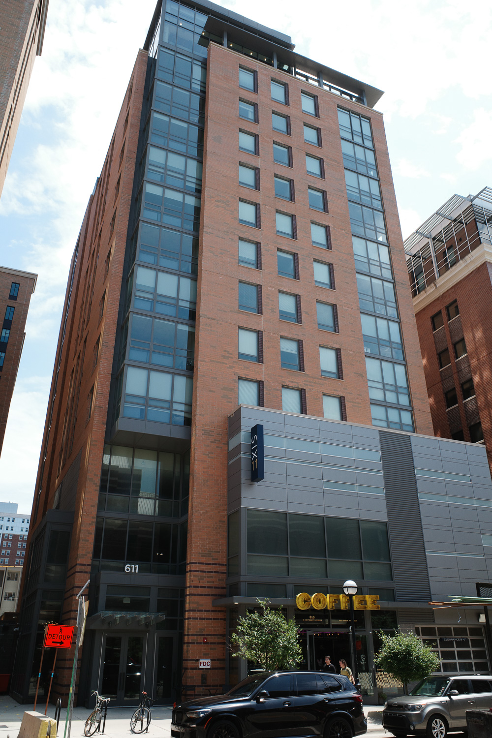 High rise apartment building with signs reading "Six 11" and "Coffee"