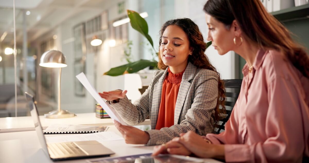 Coordinating Leave of Absence With Performance Management: colleagues discussing a document
