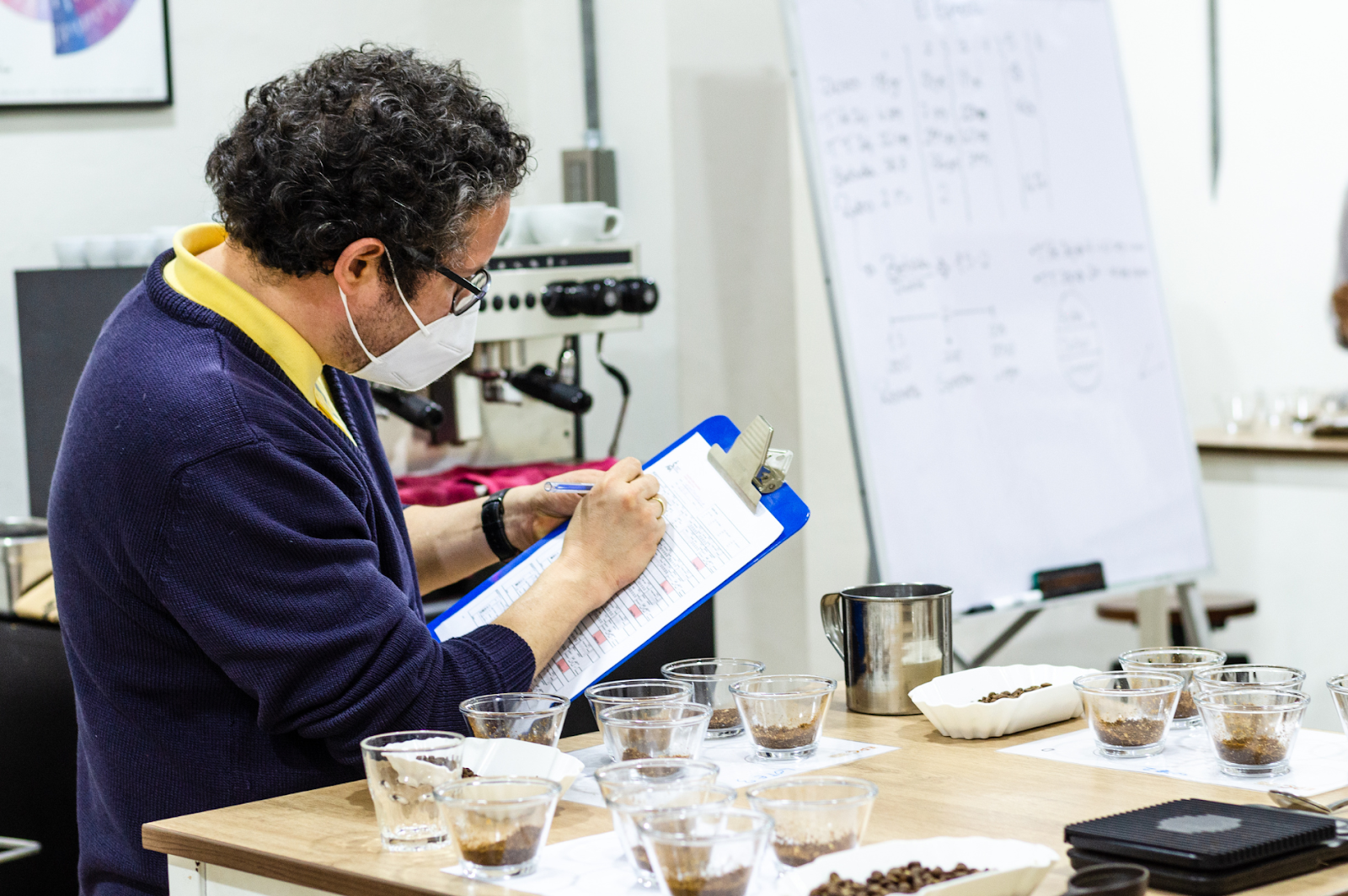 A picture of a man documenting coffee notes and taste