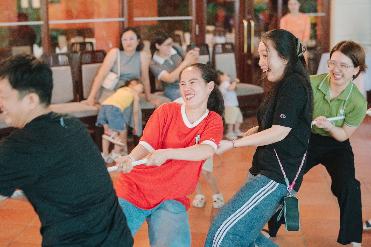 A group of people playing tug of war

Description automatically generated