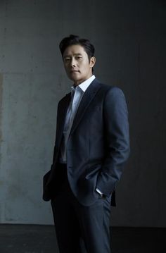 A picture of Lee Byung Hun on a black suit with his hand in his pocket 