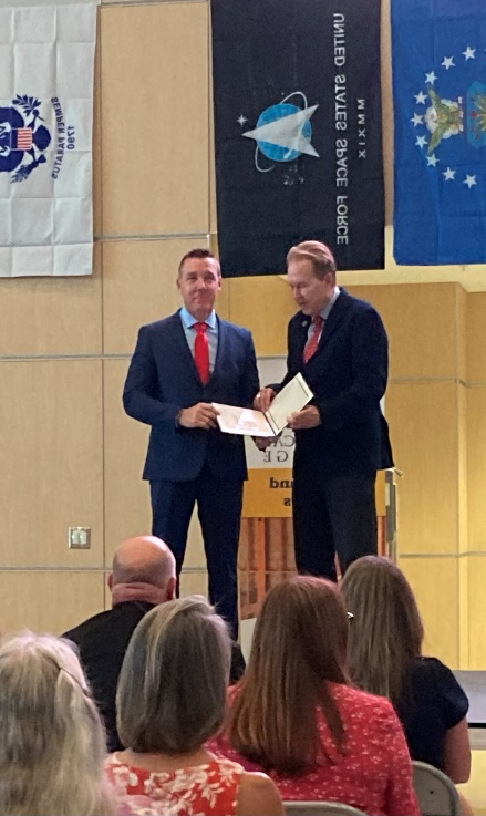 A person in suit holding a folder with a person in a suit

AI-generated content may be incorrect.