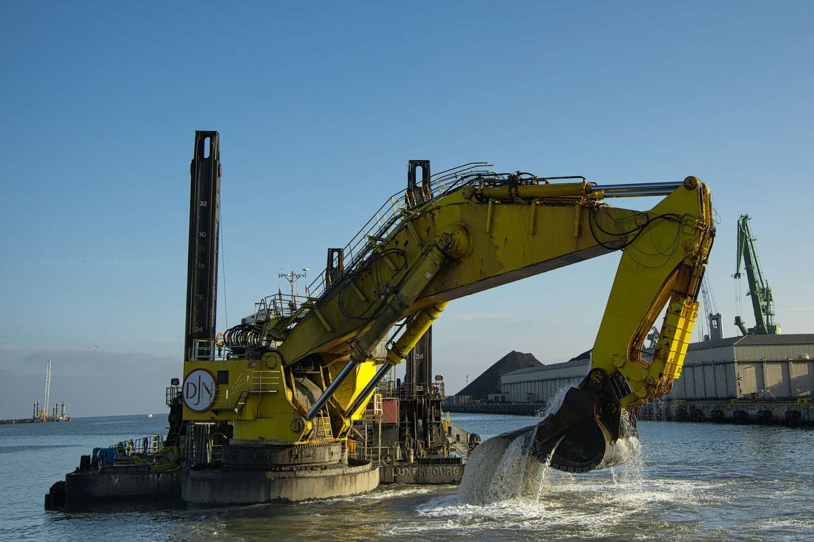 A large yellow machine is in the water.