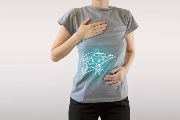 A person standing with an illuminated neon liver illustration on their torso, symbolizing liver health and detoxification.