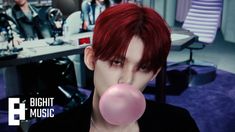 This may contain a photo of TXT blowing a bubble with red hair 