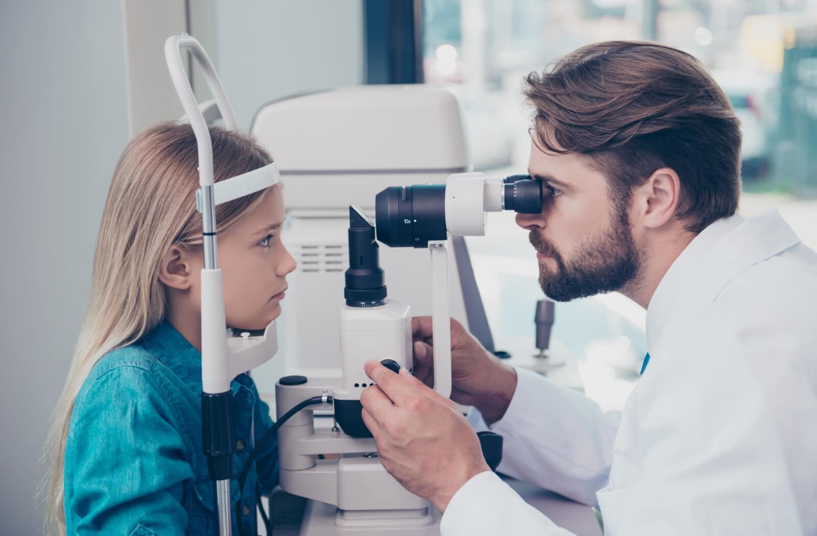 Using tonometry testing, an optometrist evaluates a young patient's eye pressure during their routine eye exam.