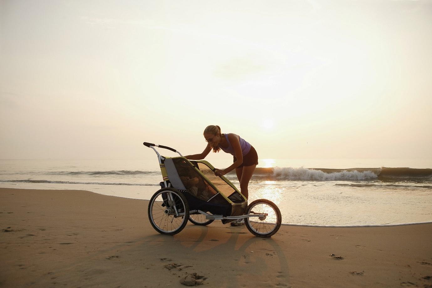 A person pushing a stroller on a beach  AI-generated content may be incorrect.