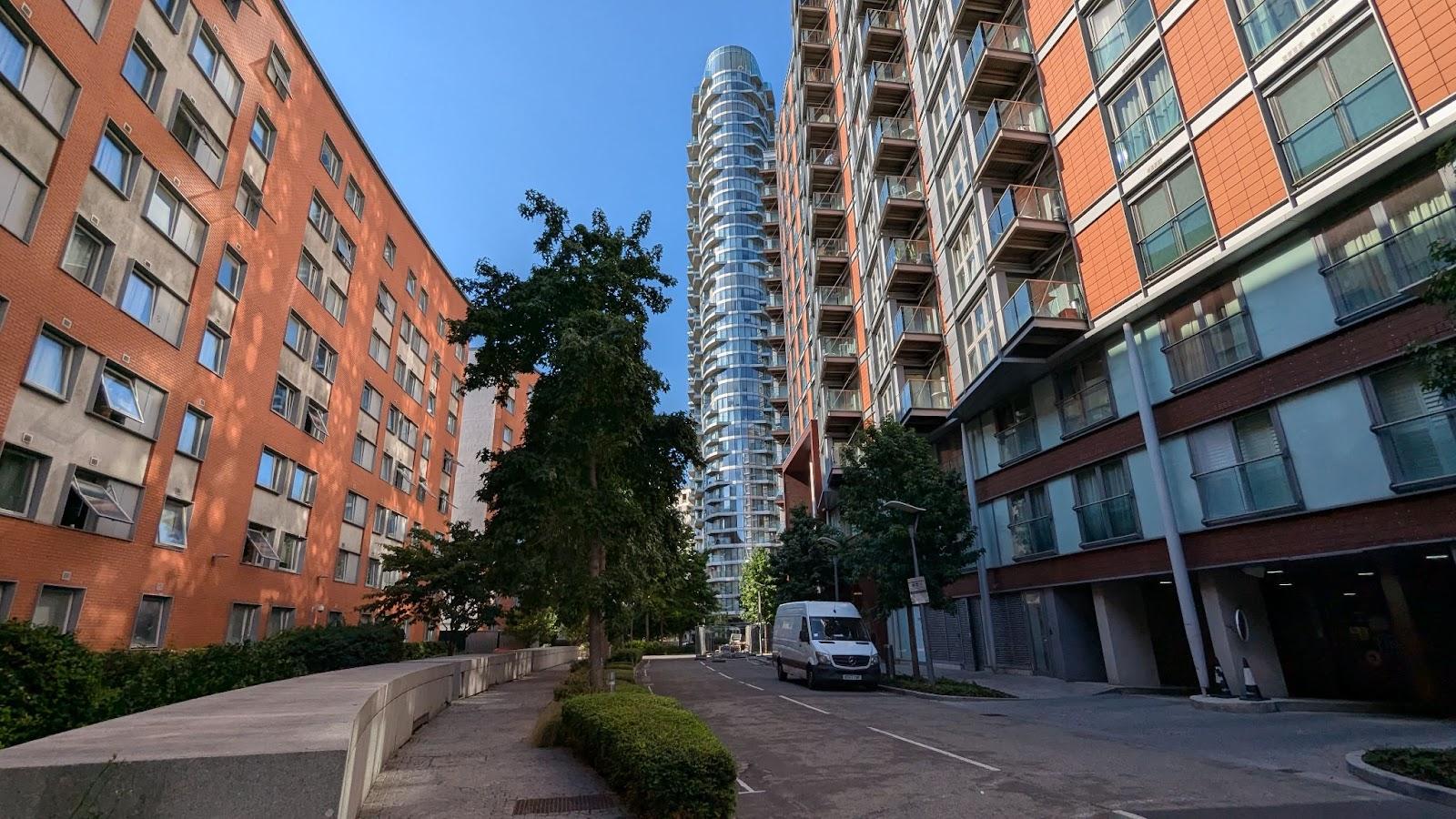 A street with a tall building and trees

AI-generated content may be incorrect.