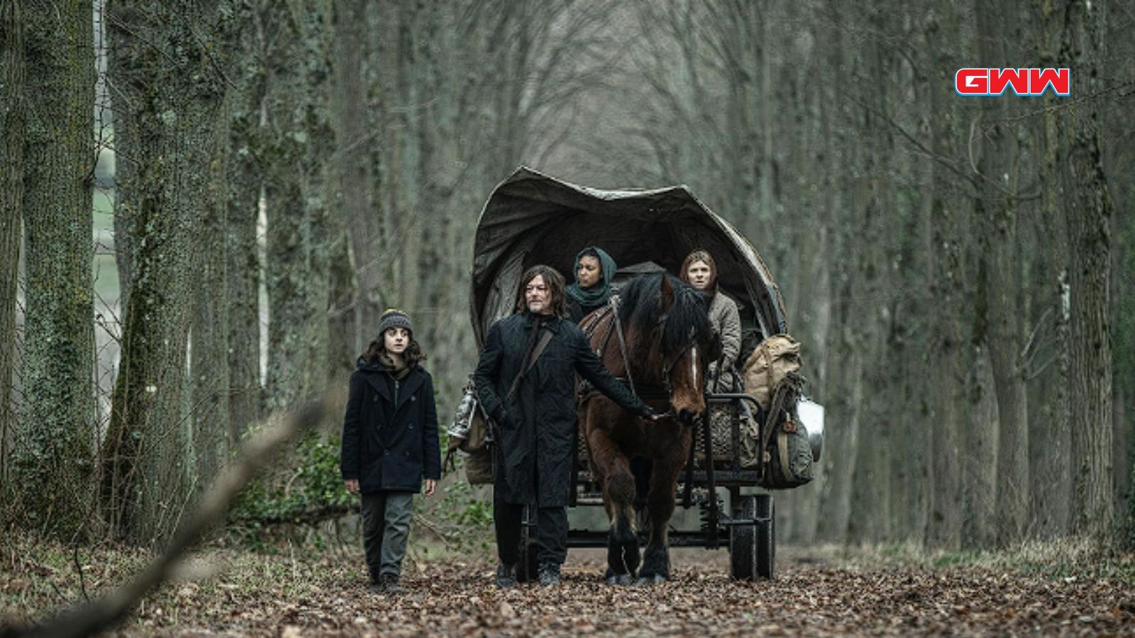 Norman Reedus as Daryl Dixon leading Clémence Poésy, Laïka Blanc-Francard, and Louis Puech Scigliuzzi through a forest