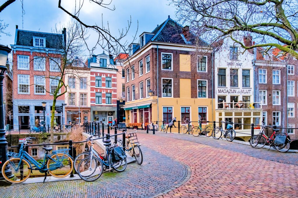 Pretty cobblestone street over a canal with colorful compact Dutch buildings