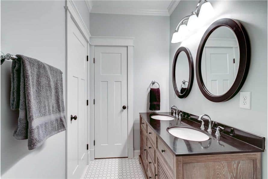 The primary bathroom features a wooden vanity with double sinks and round mirrors.