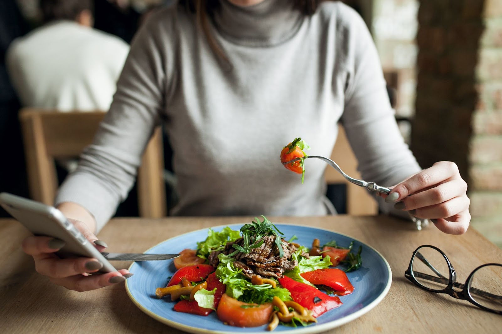 A woman is seen eating healthy nutrient-rich foods.