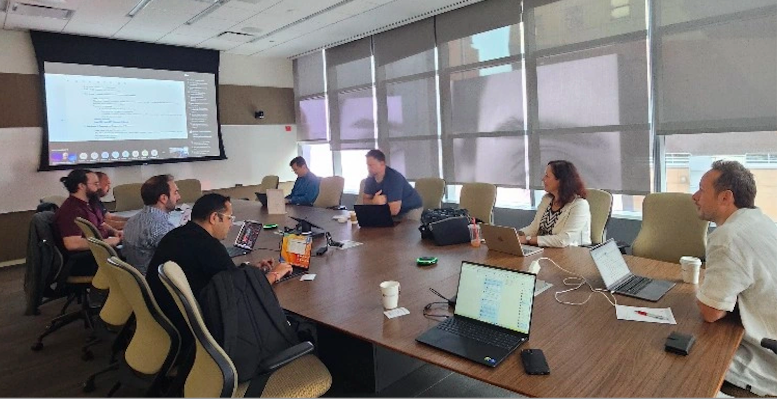 Several of the tech sprint participants around a conference table working.