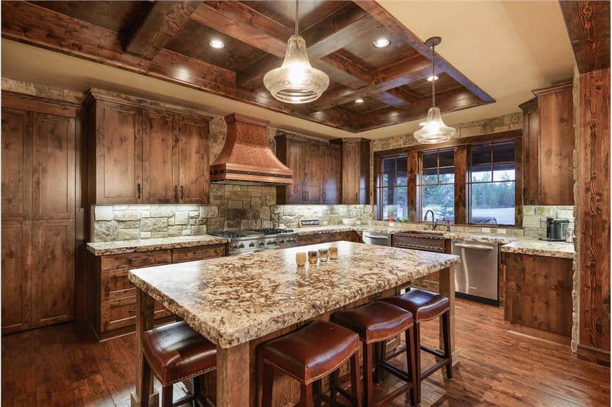 The kitchen has a wooden coffered ceiling, matching cabinetry, and a large breakfast island paired with leather bar stools.