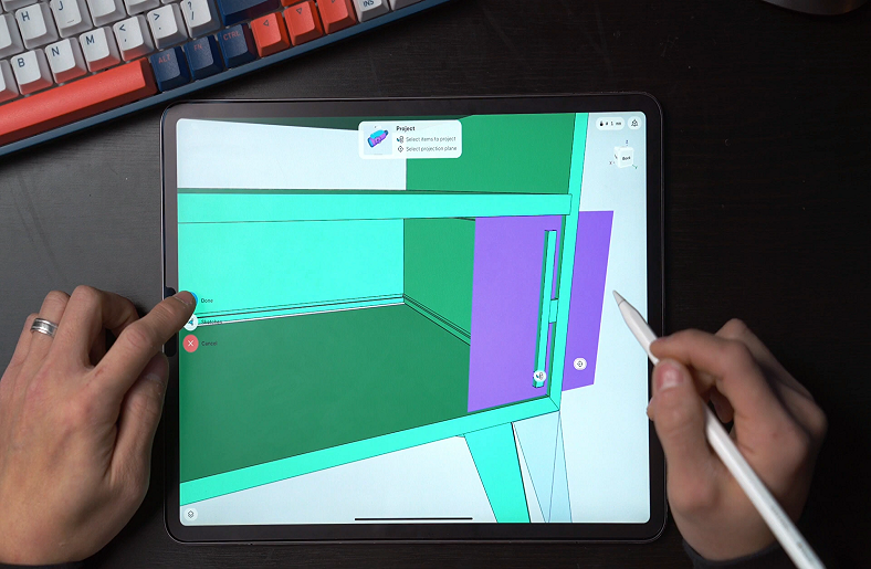Hand using a stylus to design a 3D model on a tablet.









