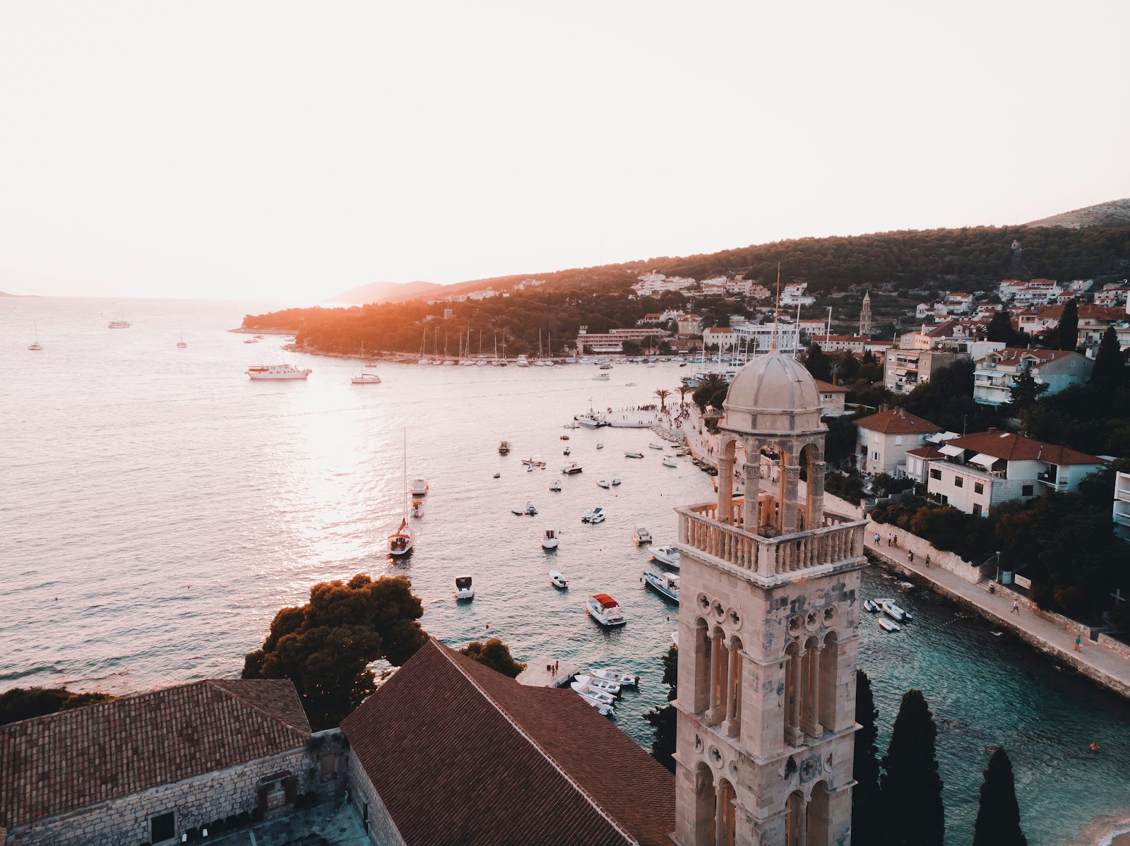 aerial photography of houses and dome building near sea at golden hour