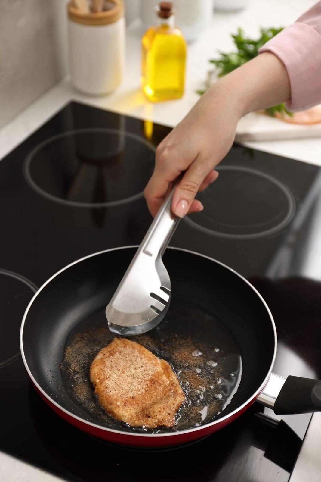 chicken cutlets being fried in a pan filled with oil