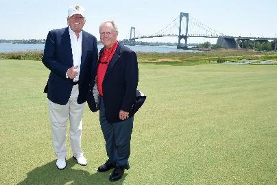 A couple of men standing on a golf course

Description automatically generated