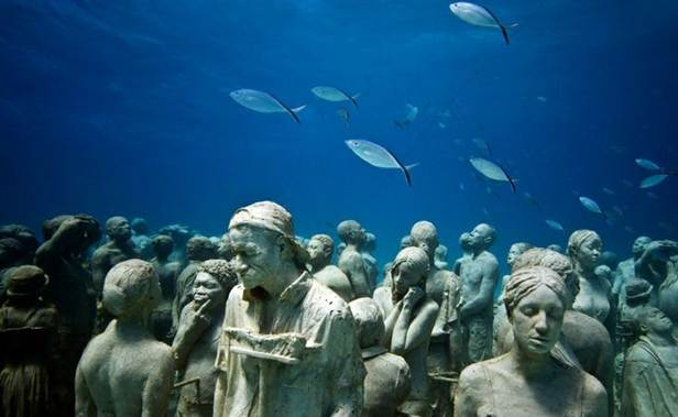 This may contain: an underwater scene with many statues and fish