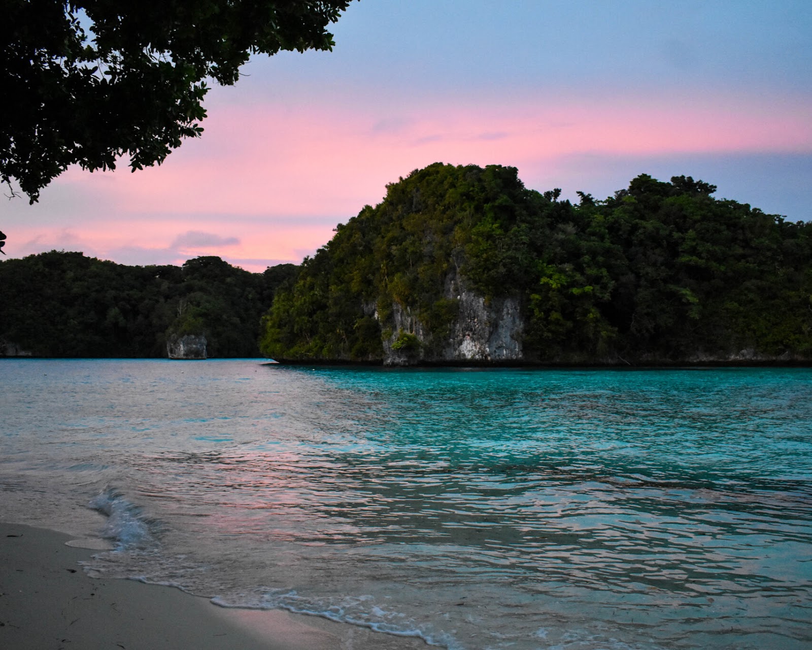 Rock Island with limestone formations in clear blue waters.