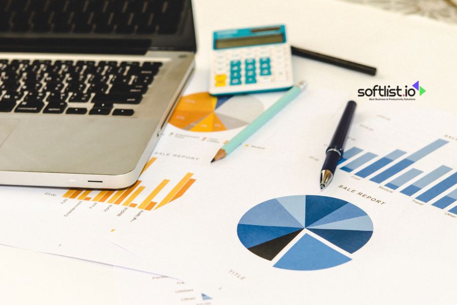 Laptop, calculator, and charts on a desk.