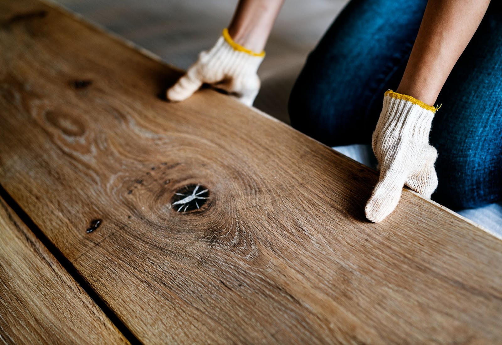 Person in gloves holding a piece of wood. 