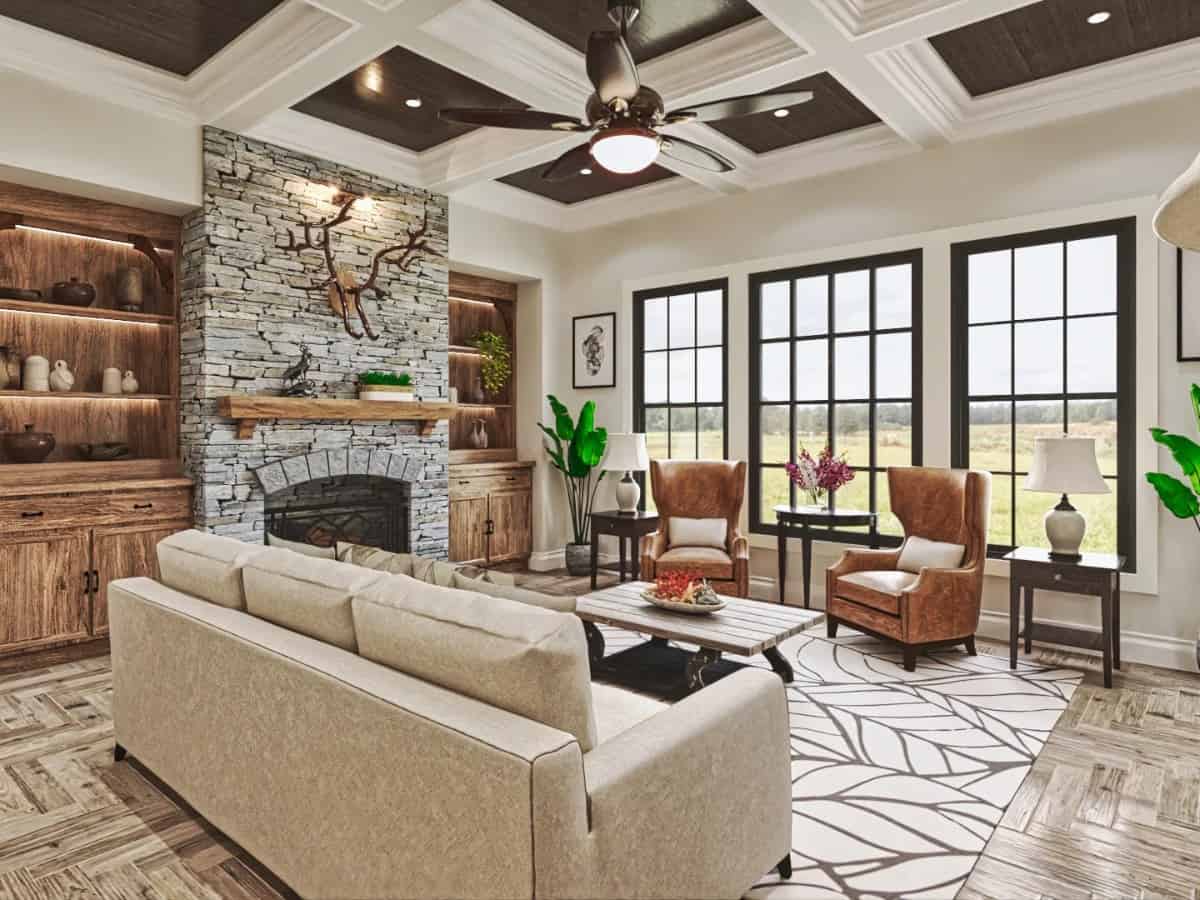 Grand room with a coffered ceiling, a stone fireplace, and a trio of windows that look out the backyard.