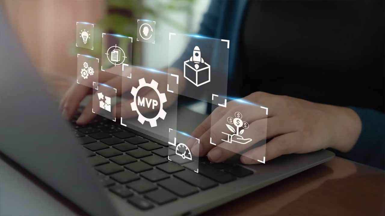 Hands typing on a laptop with MVP and feature icons, representing early-stage decisions between building or buying software solutions.