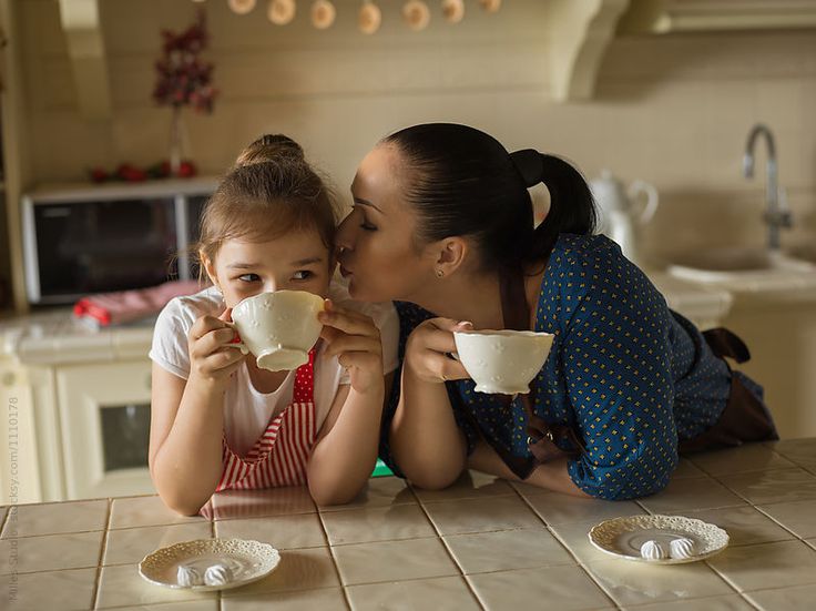 Mother's Day photoshoot capturing a mother kissing her daughter on the cheek while having coffee