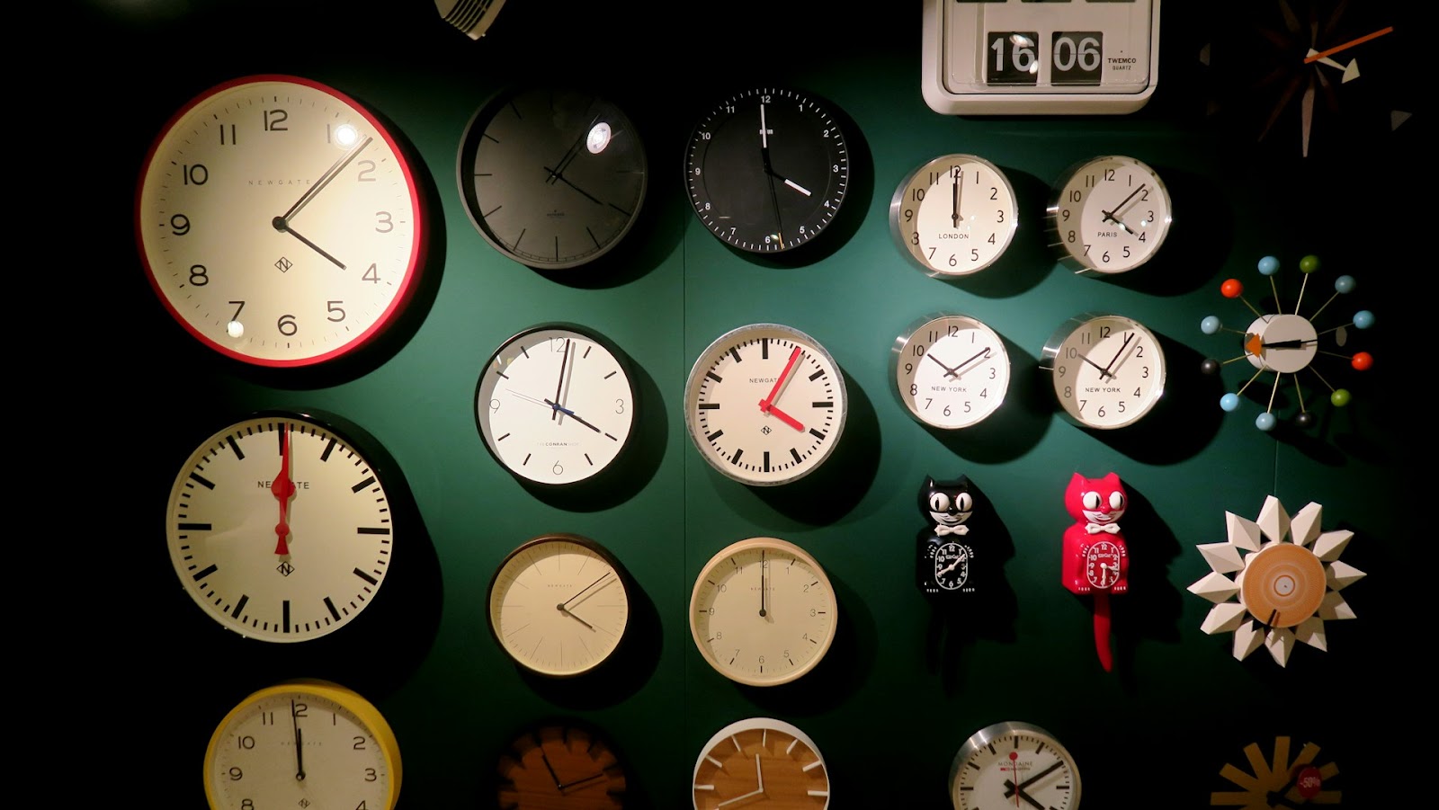 A wall covered with various clocks, each showing different times, creating a unique and eclectic timepiece display.