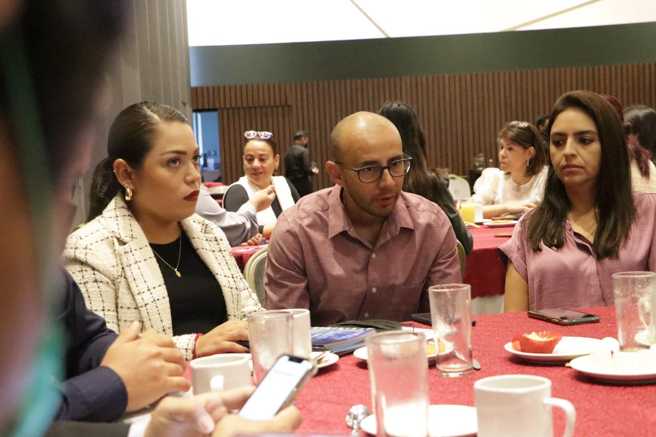 Grupo de personas sentadas alrededor de una mesa

Descripción generada automáticamente
