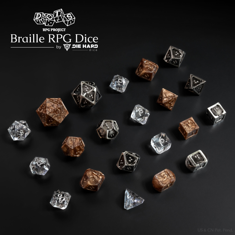 3 sets of 7 TTRPG polyhedral dice on a black surface. The first set for size comparison is a standard numbered clear plastic with silver numbers. The braille sets are metallic bronze plastic with dark pearl swirls and silver metal with black antiqued finish. Most of the braille dice are similar in size to standard numbered sets with the d20 being almost double the size. Both braille dice sets are the same style, using a single character per face on all dice. The edges around all dice faces are raised with one border having a small divot in the center to act as an orientation marker, signifying the bottom of a braille cell. The other edges around the face set are flatter and thicker to provide increased stability when reading. The metal set has small holes in the corner of all faces as the die is completely hollow. Logo in the top left corner reads DOTS RPG Project Braille RPG Dice by Die Hard Dice, US & CN Patent Pending in bottom right corner.