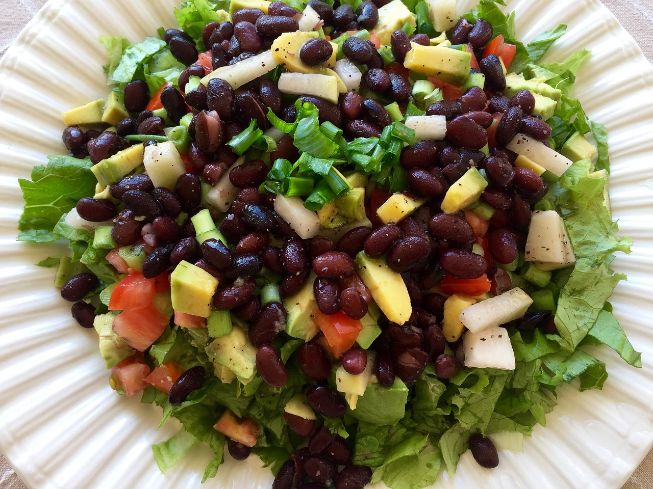 Pasto a base vegetale con fagioli, avocado, pomodori e altri alimenti integrali ricchi di fibre