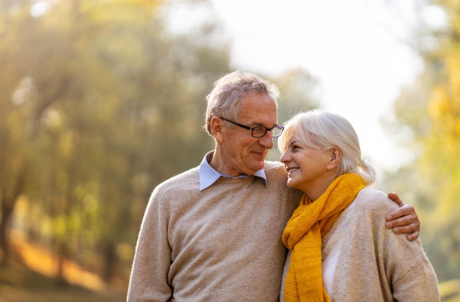 An elderly couple smiling and walking outdoors, symbolizing the potential benefits of the keto diet for seniors, such as improved energy and overall well-being.