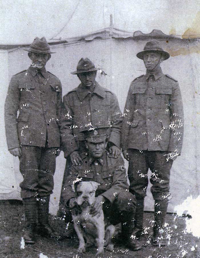 Photograph of Rifleman Thomas Samuel Tooman (s/n 26/918), Caesar\u0027s handler, standing on left and Caesar, being held by Private Albert Edward Griffin (s/n 3/1513).