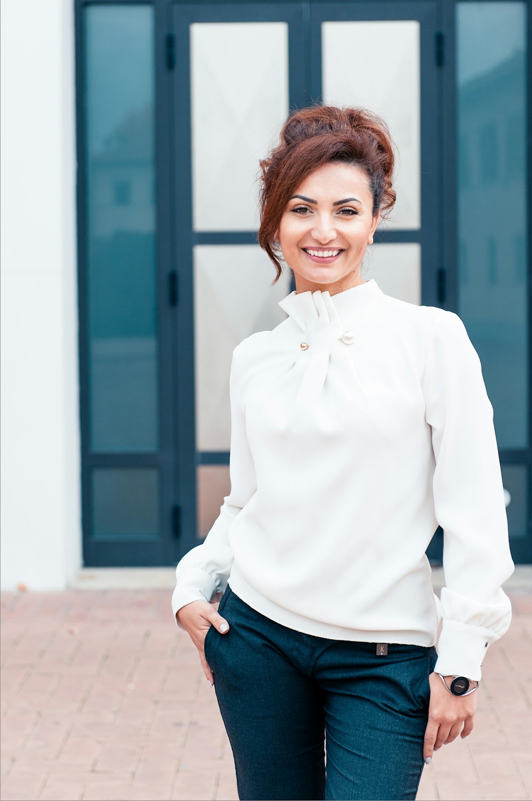 A woman dressed classy in white and black posing for a professional photo