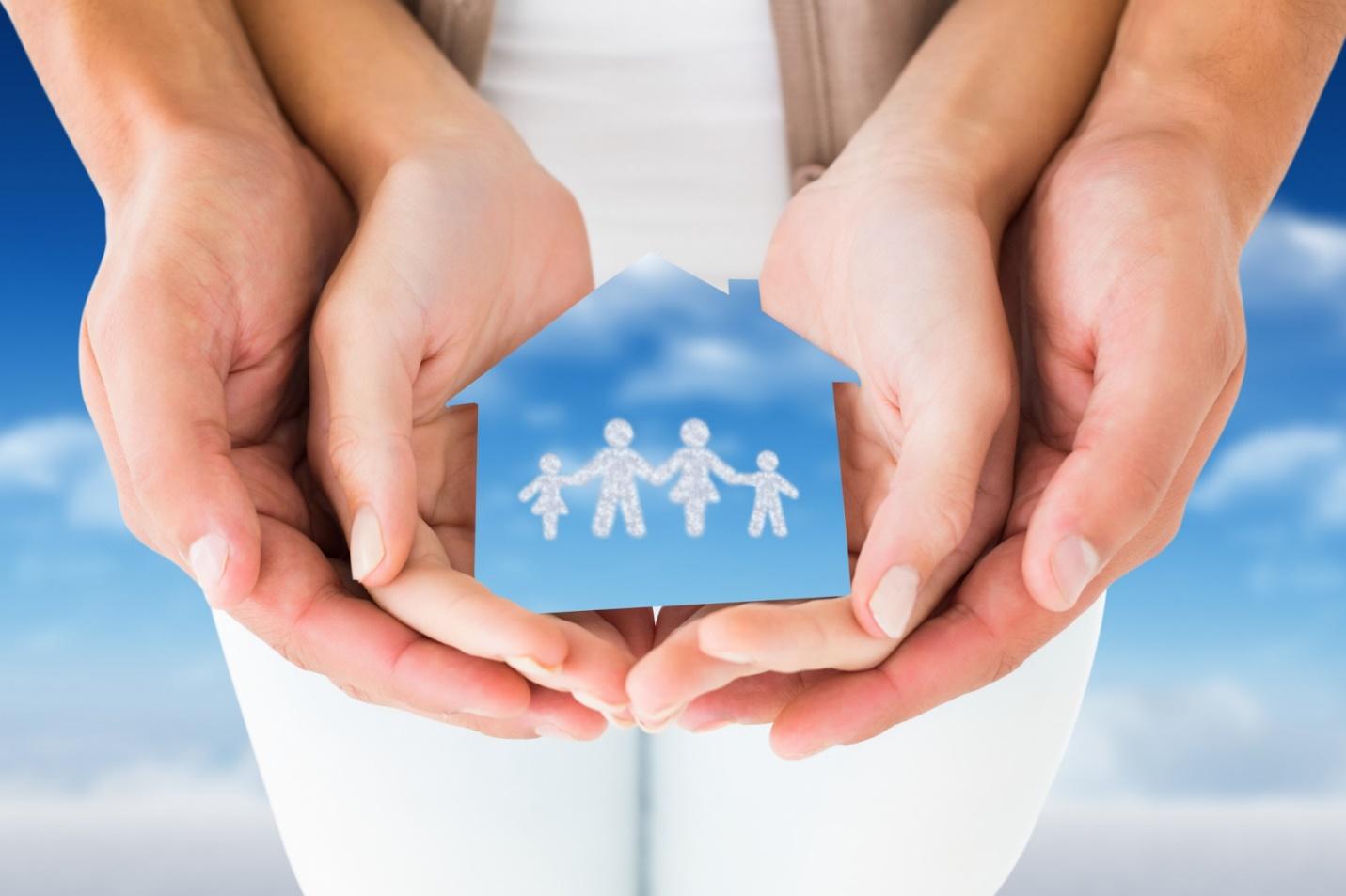 Hands holding a paper house with family imagesAI-generated content may be incorrect.