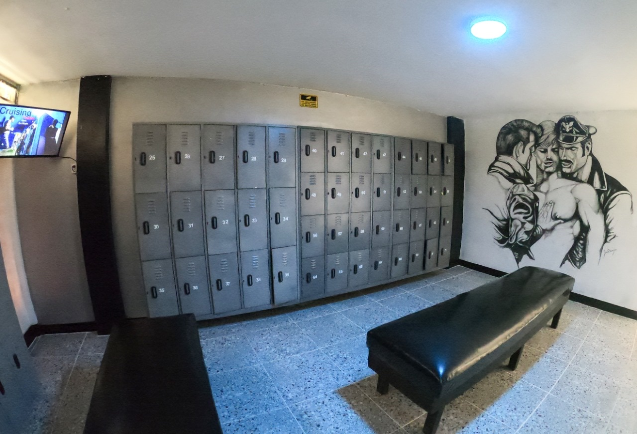 gay sauna locker room showing a wall mural of gay leather art tom of finland in Medellin Colombia's gay bathhouse Sauna Cruising
