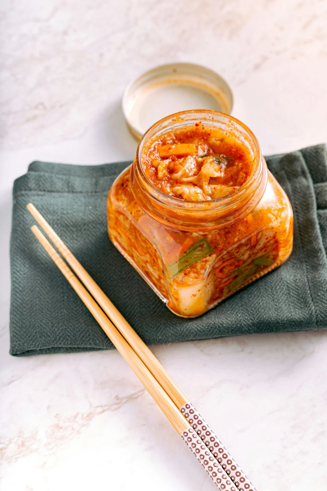 korean cusine kimchi in glass jar with chopsticks 