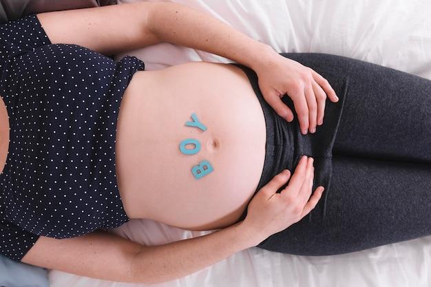 Pregnant woman with boy letters